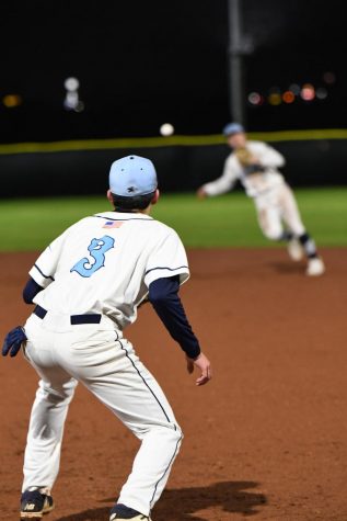 In their second game on the new field, senior shortstop Hunter Wood attempts to throw a Shiloh runner out to senior first baseman Todd Girdner. The Wildcats lost to the Saints 11-1 on March 13.