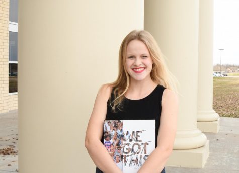 Senior Journalist of the Year, Maddy Stout holds All American award winning 2019 yearbook in front of Har-Ber High School
