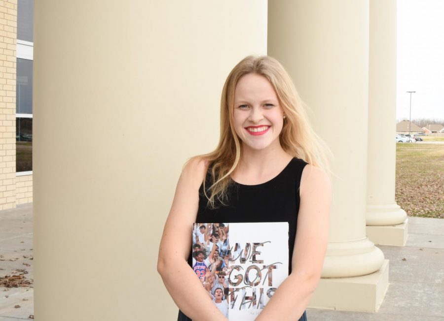 Senior Journalist of the Year, Maddy Stout holds All American award winning 2019 yearbook in front of Har-Ber High School 