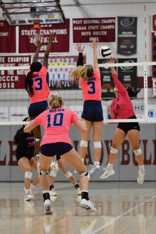 Seniors Kenleigh Hall (23) and Caylan Koons (3) block the ball against the Springdale Bulldogs on Oct. 5. The Wildcats defeated Springdale in three straight sets in the conference match. 