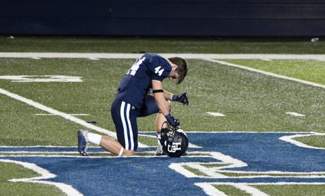 Senior linebacker Chris McGehee kneels to pray at the 50-yard line after a Senior Night loss to Fayetteville. 