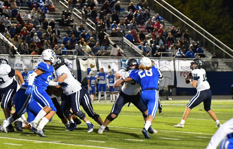 Sophomore quarterback Rhett Richards drops back to look for a receiver against the Rogers Mounties. Richardson replaced senior quarterback Luke Buchanan, who has been moved to running back and safety.